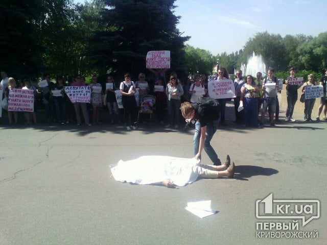 Накриті білими простирадлами «трупи» лежать під виконкомом міськради Кривого Рогу