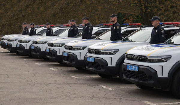 Полицейские офицеры общины стоят рядом с новыми служебными автомобилями Renault Duster в Кривом Роге