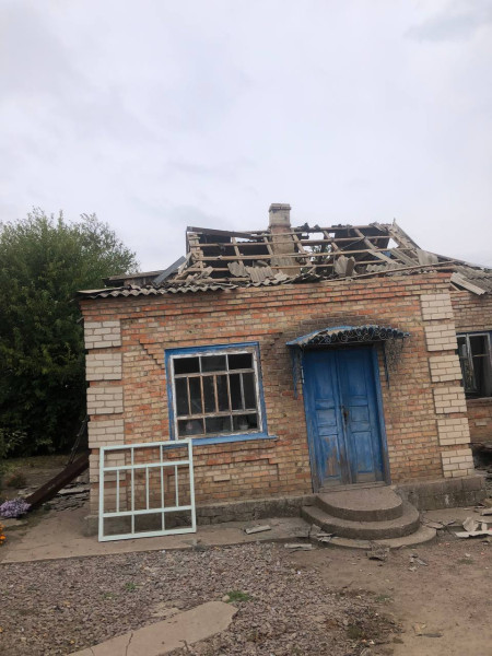 Пошкоджений російськими атаками житловий будинок у селі Мар'янське Криворізького району зі зруйнованим дахом і вибитими вікнами