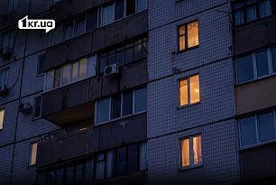 Многоэтажный жилой дом в Кривом Роге вечером, в нескольких квартирах светятся окна