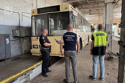 Следователи полиции и прокуратуры возле троллейбуса в ремонтном цехе депо