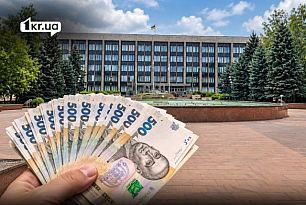 Украинские 500 гривен в руке на фоне здания исполкома Криворожского городского совета