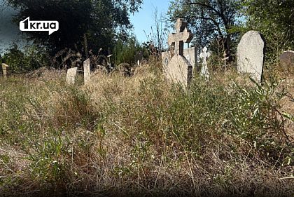 Старые могилы и каменные кресты среди высокой травы на кладбище
