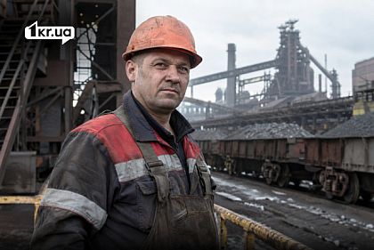 Работник металлургического предприятия в каске на фоне промышленных цехов