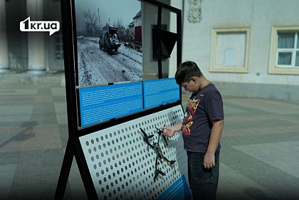 Дитина розглядає експонат виставки «Гуманітарна система під ударом» місії «Проліска» у Кривому Розі