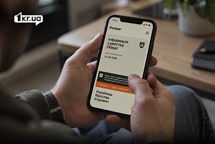 Мужчина держит смартфон с открытым приложением «Резерв+» и информацией из реестра «Оберіг»