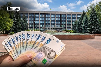 Украинские 500 гривен в руке на фоне здания исполкома Криворожского городского совета