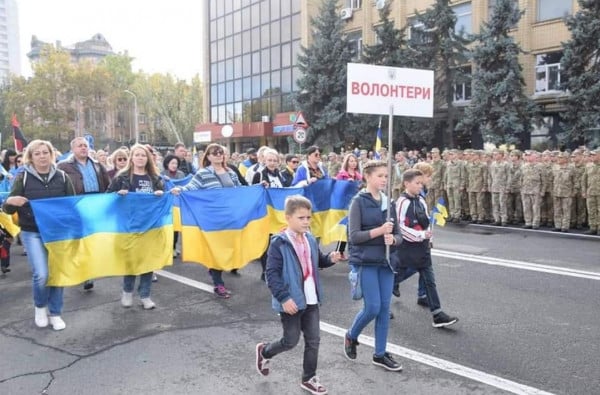 Лідія з табличкою «Волонтери» 14.10.2019 року на урочистому марші Захисників в Миколаєві