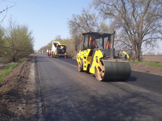 Сотрудники службы автодорог выполняют ремонтные работы на участке дороги на трассе Днепр-Кривой Рог-Николаев