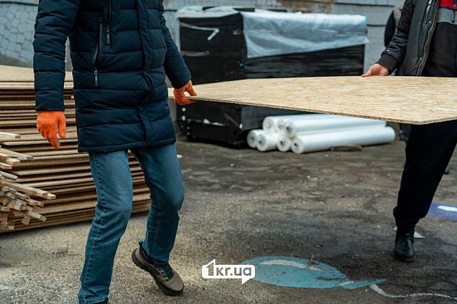 люди несуть дсп для перекриття розбитих вікон