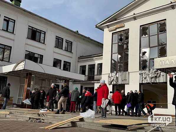 штаб допомоги на фоні пошкодженої будівлі