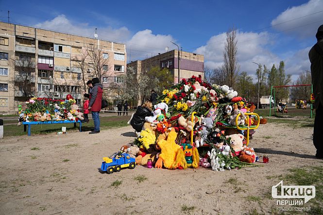 игрушки и цветы на детской площадке на месте удара