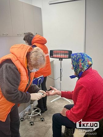 Медработница мобильной клиники берет кровь из пальца у пациентки в Криворожском районе