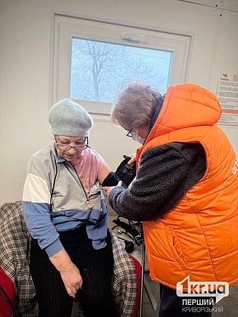 Медработница измеряет артериальное давление пациентке мобильной клиники в Криворожском районе