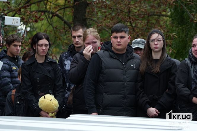 Члени родини плачуть біля білих трун під час прощання з п'ятьма дітьми, які загинули внаслідок російської атаки 30 липня у Радушному Криворізького району.