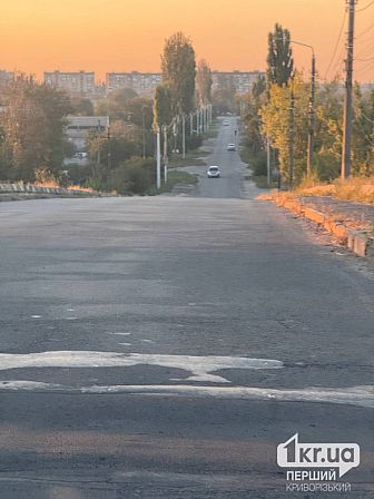 Пошкоджена асфальтована дорога з великою вибоїною на проїжджій частині у Довгинцівському районі Кривого Рогу