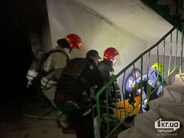 Рятувальники ДСНС спускають постраждалого чоловіка на ношах сходами багатоповерхівки під час пожежі у Кривому Розі