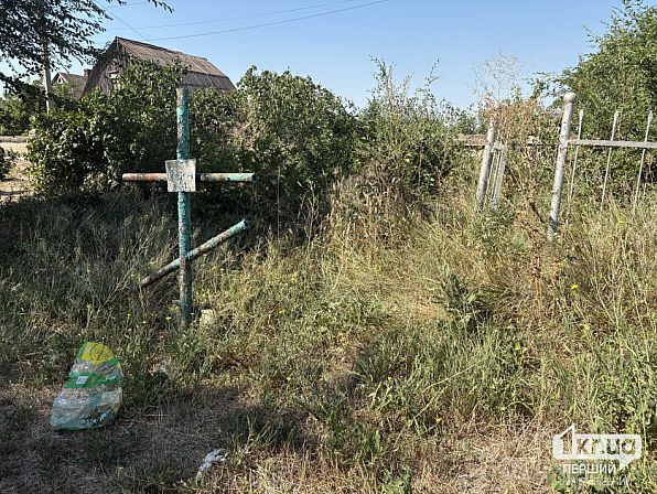 Заросшая травой могила и наклонившаяся металлическая ограда на Широковском кладбище в Кривом Роге